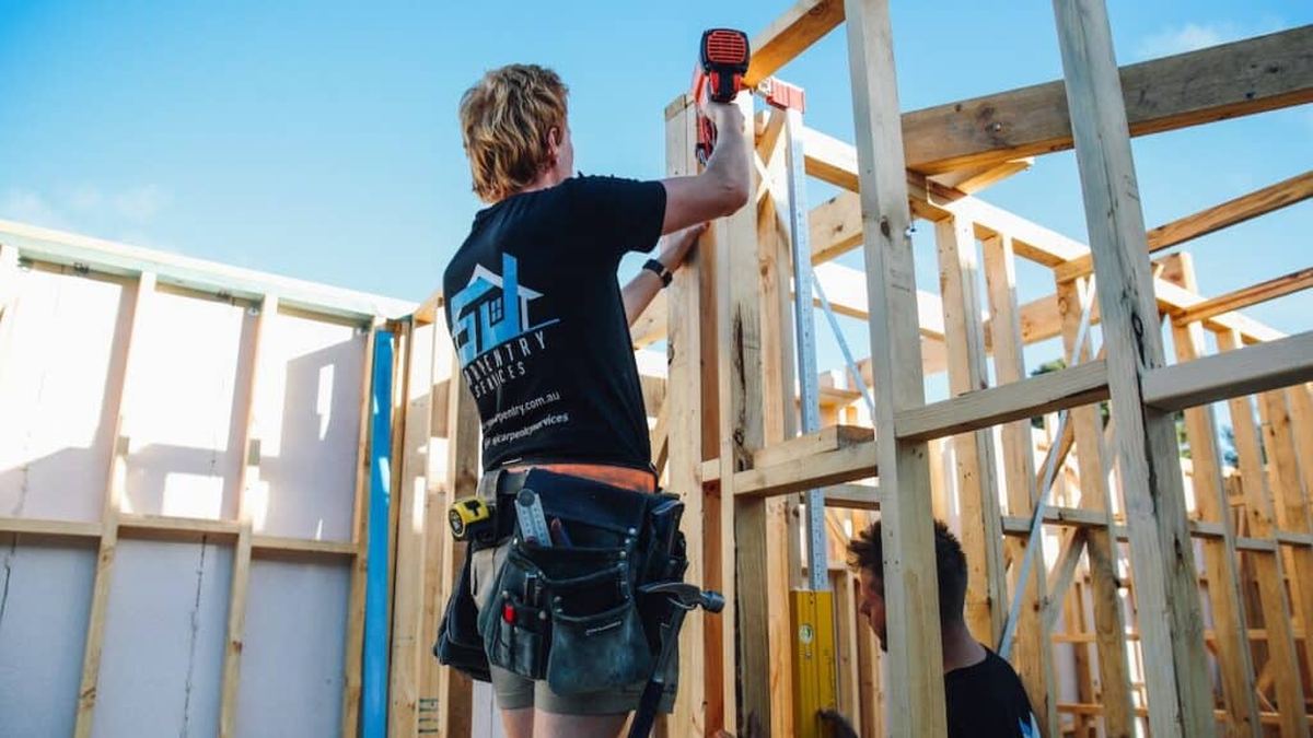 Carpenter fixing timber wall framing on a house build